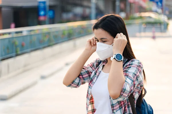 Çevre kirliliğini ve virüsü korumak için N95 maskesi takan Asyalı kadın. Covid-19 Coronavirus ve Hava kirliliği pm2.5 kavramı.