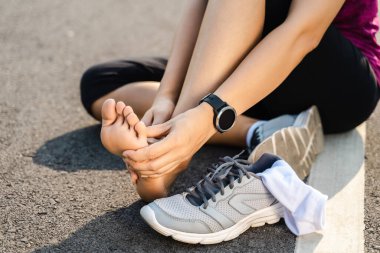 Koşu, bacak kazası, spor koşucusu yaralı yaralı, bileği burkulmuş, ağrısı var. Eklem ya da kas ağrısı ve alt vücudunda ağrı olan bir bayan sporcu..