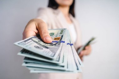 İş kadınlarının eli, beyaz arka planda bize para teklif ediyor. Para Konsepti.