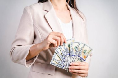 İş kadınlarının elleri bize beyaz arka planda dolar sayıyor. Para Konsepti.
