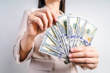 İş kadınlarının elleri bize beyaz arka planda dolar sayıyor. Para Konsepti.