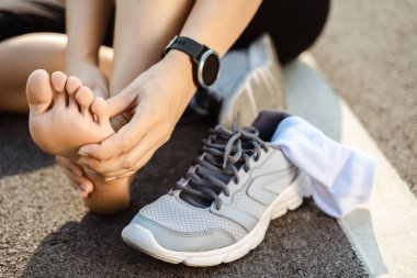 Koşu, bacak kazası, spor koşucusu yaralı yaralı, bileği burkulmuş, ağrısı var. Eklem ya da kas ağrısı ve alt vücudunda ağrı olan bir bayan sporcu..