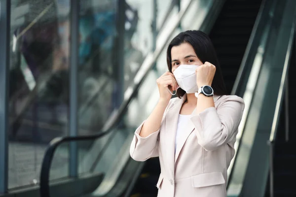Çevre kirliliğini ve virüsü korumak için N95 maskesi takan Asyalı kadın. Covid-19 Coronavirus ve Hava kirliliği pm2.5 kavramı.