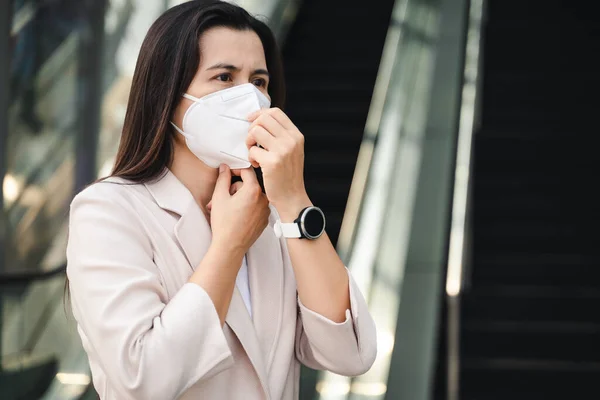 Çevre kirliliğini ve virüsü korumak için N95 maskesi takan Asyalı kadın. Covid-19 Coronavirus ve Hava kirliliği pm2.5 kavramı.