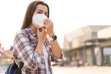 Çevre kirliliğini ve virüsü korumak için N95 maskesi takan Asyalı kadın. Covid-19 Coronavirus ve Hava kirliliği pm2.5 kavramı.