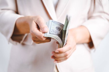 İş kadınlarının elleri bize beyaz arka planda dolar sayıyor. Para Konsepti.