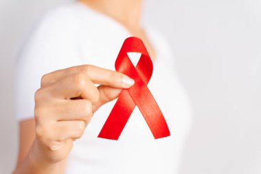 Tatlı kadın el holding kırmızı kurdele HIV, Dünya AIDS günü bilinçlendirme şerit. Sağlık ve tıp kavramı.