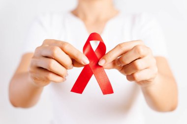 Tatlı kadın el holding kırmızı kurdele HIV, Dünya AIDS günü bilinçlendirme şerit. Sağlık ve tıp kavramı.