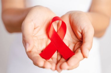 Tatlı kadın el holding kırmızı kurdele HIV, Dünya AIDS günü bilinçlendirme şerit. Sağlık ve tıp kavramı.