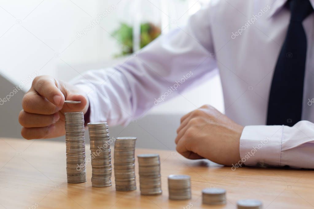 Saving money concept preset, the young man arranged the coins like a graph of the growing business, which made him have a driving force in his work.