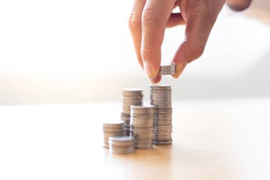 Eller madeni parayı en üste koyar, İşadamları gelir hesaplayarak bir mali plan hazırlar - istikrarlı iş büyüme fikirleri için harcamalar, para tasarrufu kavramı