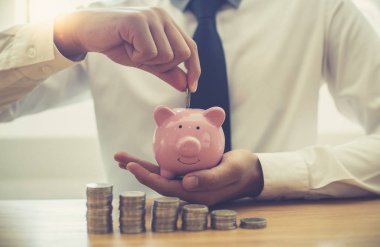 El ele tutuşan paralar domuz kumbarasına, iş adamları gelir hesaplayarak finansal bir plan hazırlıyorlar - istikrarlı iş büyüme fikirleri için harcamalar, tasarruf para kavramı