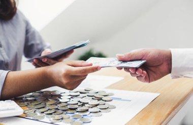 Bir işadamının elleri, çalışanlarının şirketin mali başarısına katkıda bulunması için büyük miktarda para tutuyor.