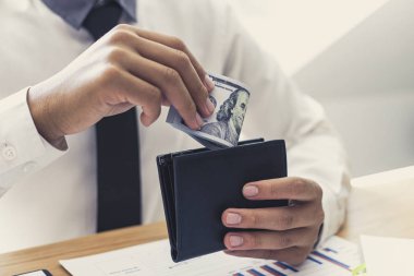 Şirketinin kurduğu mali ve muhasebe başarısından elde ettiği kara bir çantada bir dolar tutan bir işadamının elleri. Para kavramı..