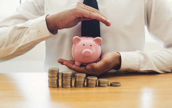 The businessman works in his account protecting money to reduce the risk of business investments and increasing work security plans, Saving money and finance concept