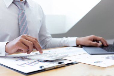 İşadamları emlak yatırımlarının maliyetini hesaplamak için hesap makineleri kullanırlar ve şirket Business Financ Concept ile hisse paylaşmak isteyen müşterilere teklif sunmaya hazırlanırlar.