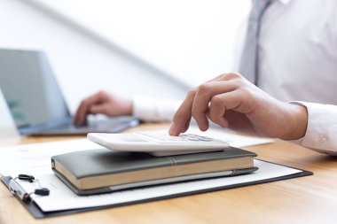 İşadamları emlak yatırımlarının maliyetini hesaplamak için hesap makineleri kullanırlar ve şirket Business Financ Concept ile hisse paylaşmak isteyen müşterilere teklif sunmaya hazırlanırlar.