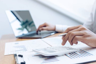 İşadamları emlak yatırımlarının maliyetini hesaplamak için hesap makineleri kullanırlar ve şirket Business Financ Concept ile hisse paylaşmak isteyen müşterilere teklif sunmaya hazırlanırlar.