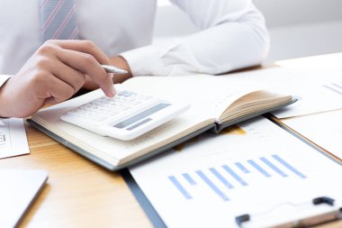 İşadamları emlak yatırımlarının maliyetini hesaplamak için hesap makineleri kullanırlar ve şirket Business Financ Concept ile hisse paylaşmak isteyen müşterilere teklif sunmaya hazırlanırlar.