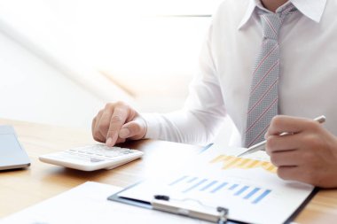 İşadamları emlak yatırımlarının maliyetini hesaplamak için hesap makineleri kullanırlar ve şirket Business Financ Concept ile hisse paylaşmak isteyen müşterilere teklif sunmaya hazırlanırlar.