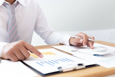 İşadamları emlak yatırımlarının maliyetini hesaplamak için hesap makineleri kullanırlar ve şirket Business Financ Concept ile hisse paylaşmak isteyen müşterilere teklif sunmaya hazırlanırlar.