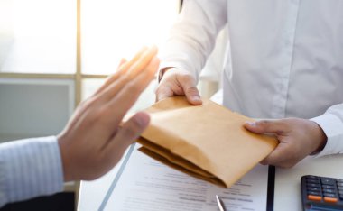 İş adamı, iş sözleşmesi, rüşvet ve yolsuzlukla mücadele konseptini imzalamak için parayı kahverengi zarfta almayı reddediyor.