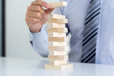 İş adamları birlikte ahşap oyunlar oynar, bir işletmenin ortalama yatırım değerini böler ve riskleri ortaklaşa yönetir, Alternatif risk planı ve iş stratejisi.