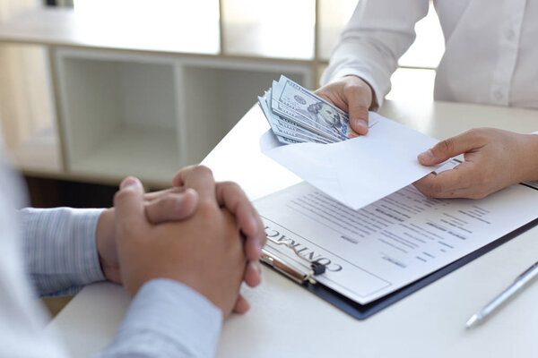  Businessmen make dollar payments while signing an investment agreement to be a partner in an illegal and successful manner, Bribery and corruption concept