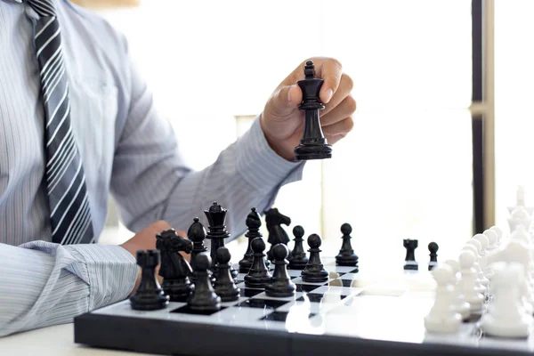 Business strategy, Businessman have the skills to play chess and be successful, management or leadership concept