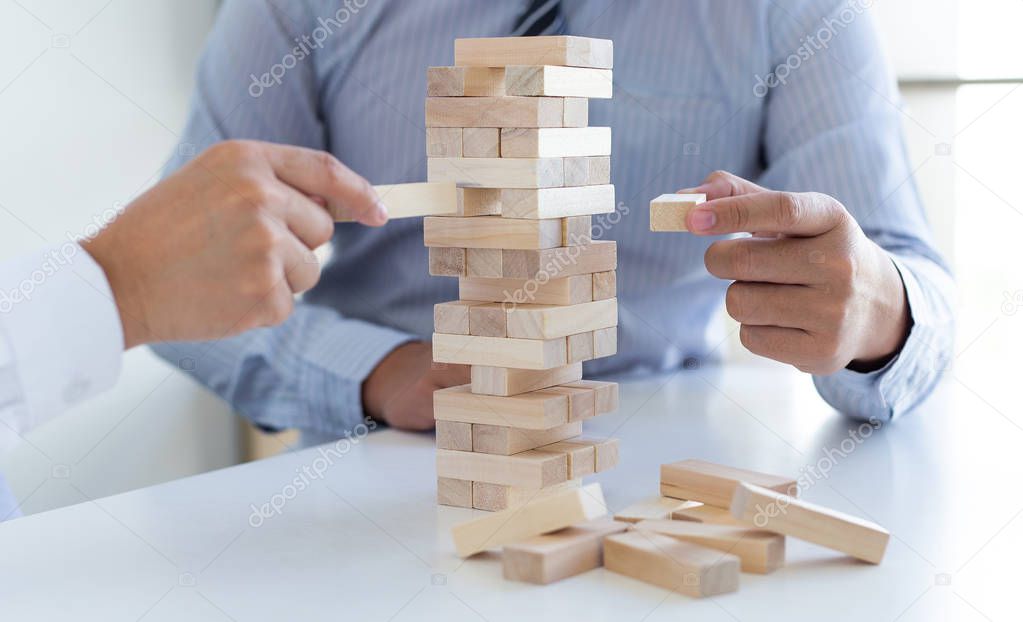Business people play wooden games together, divide the average investment value of a business and jointly manage risks, Alternative risk plan and strategy in business.