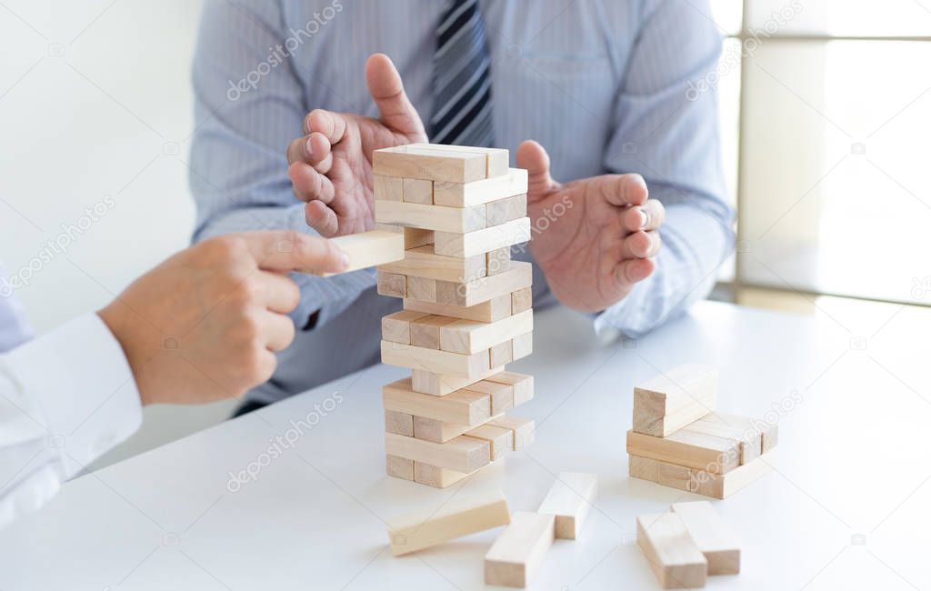 Business people play wooden games together, divide the average investment value of a business and jointly manage risks, Alternative risk plan and strategy in business.