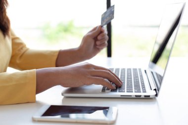 Kadınlar çevrimiçi alışverişler, çevrimiçi alışveriş veya internet teknolojisi konsepti yapmak için kredi kartlarıyla dizüstü bilgisayarı kullanıyorlar.