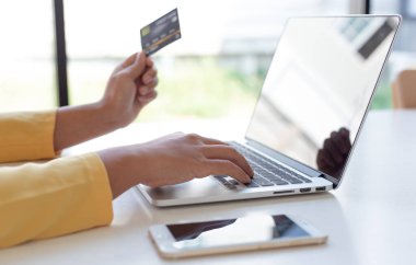 Kadınlar çevrimiçi alışverişler, çevrimiçi alışveriş veya internet teknolojisi konsepti yapmak için kredi kartlarıyla dizüstü bilgisayarı kullanıyorlar.