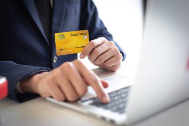 İşadamı çevrimiçi alışveriş kavramı oluşturmak için kredi kartlarıyla laptop kaydı kullanıyor..
