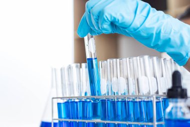 Bilim insanları kimyasal bileşimin ve biyolojik kütlesinin bilimsel bir laboratuvarda, bilim adamlarında ve laboratuar konseptinde tespit edilmesine hazırlanmak için mavi kimyasal test tüpleri taşıyorlar..