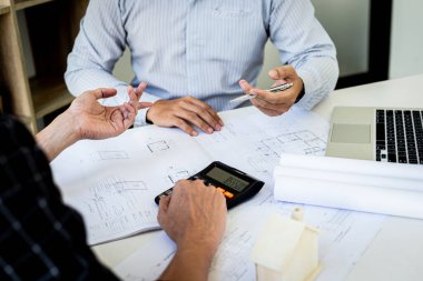 Mühendisler ya da mimarlar, mimari yapıyı tasarlamak için bir ekiple buluşacak. Çalışma alanı, teknolojik yapı ve inşaat alanındaki planlar ve model binalarla birlikte..