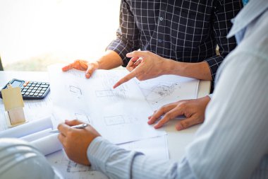 Mühendisler ya da mimarlar, mimari yapıyı tasarlamak için bir ekiple buluşacak. Çalışma alanı, teknolojik yapı ve inşaat alanındaki planlar ve model binalarla birlikte..