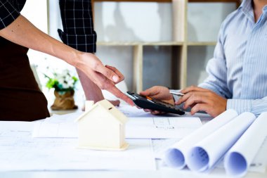 Mühendisler ya da mimarlar, mimari yapıyı tasarlamak için bir ekiple buluşacak. Çalışma alanı, teknolojik yapı ve inşaat alanındaki planlar ve model binalarla birlikte..