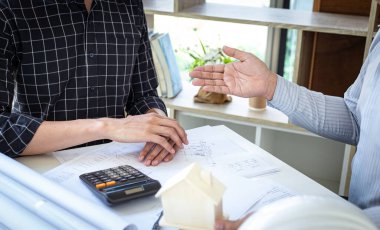 Mühendisler ya da mimarlar, mimari yapıyı tasarlamak için bir ekiple buluşacak. Çalışma alanı, teknolojik yapı ve inşaat alanındaki planlar ve model binalarla birlikte..