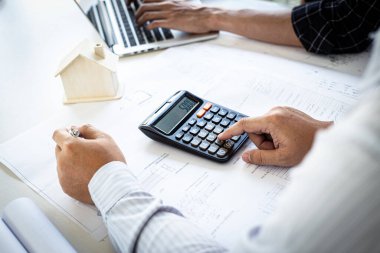 Mühendisler ya da mimarlar, mimari yapıyı tasarlamak için bir ekiple buluşacak. Çalışma alanı, teknolojik yapı ve inşaat alanındaki planlar ve model binalarla birlikte..