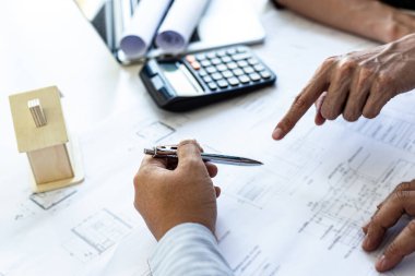 Mühendisler ya da mimarlar, mimari yapıyı tasarlamak için bir ekiple buluşacak. Çalışma alanı, teknolojik yapı ve inşaat alanındaki planlar ve model binalarla birlikte..