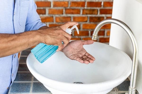 Young man is washing his hands in a sink sanitizing the colona virus for sanitation and reducing the spread of COVID-19 spreading throughout the world, Hygiene ,Sanitation concept.