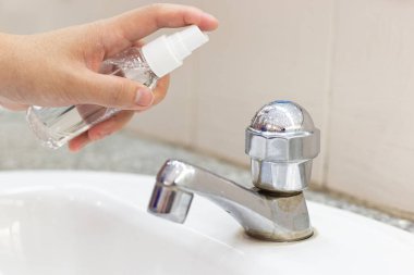 Kadın ellerine% 70 oranında alkol enjekte ediliyor. Bakterileri ve koronal virüsü öldürüyorlar. Ya da virüsleri önlemek için covid-19 virüsü..