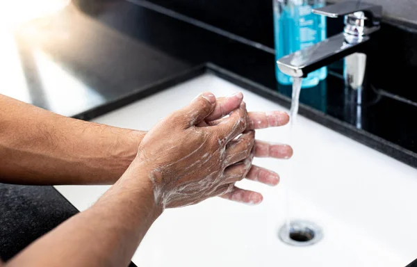 Man is washing his hands in a sink sanitizing the colona virus for sanitation and reducing the spread of COVID-19 spreading throughout the world, Hygiene ,Sanitation concept.