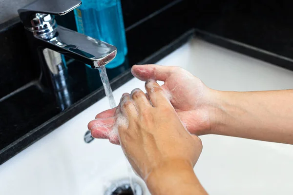 Man is washing his hands in a sink sanitizing the colona virus for sanitation and reducing the spread of COVID-19 spreading throughout the world, Hygiene ,Sanitation concept.