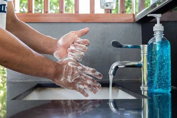 Man is washing his hands in a sink sanitizing the colona virus for sanitation and reducing the spread of COVID-19 spreading throughout the world, Hygiene ,Sanitation concept.