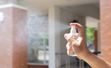 Adam bakteri ve virüslerden kurtulmak, Covid-19 virüsünü engellemek ve engellemek için alkol spreyi kullanıyor..