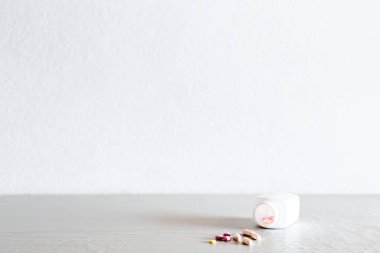  Tıbbi konsept, şişeden çok renkli haplar döküldü, hastaları tedavi etmek ve acıyı dindirmek için kullanılan ilaçlar antiseptikler, mesaj için kopyalama alanı..