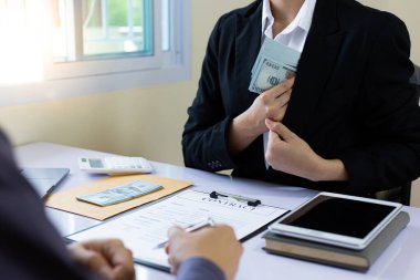 İşadamları, yasadışı arazi ve gayrimenkul, iş dolandırıcılığı ve sosyal adaletsizlik, yolsuzluk ve rüşvet kavramını satın almak için sözleşmeler imzalayan çalışanlara dolar dağıtıyor.