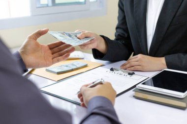 İşadamları, yasadışı arazi ve gayrimenkul, iş dolandırıcılığı ve sosyal adaletsizlik, yolsuzluk ve rüşvet kavramını satın almak için sözleşmeler imzalayan çalışanlara dolar dağıtıyor.